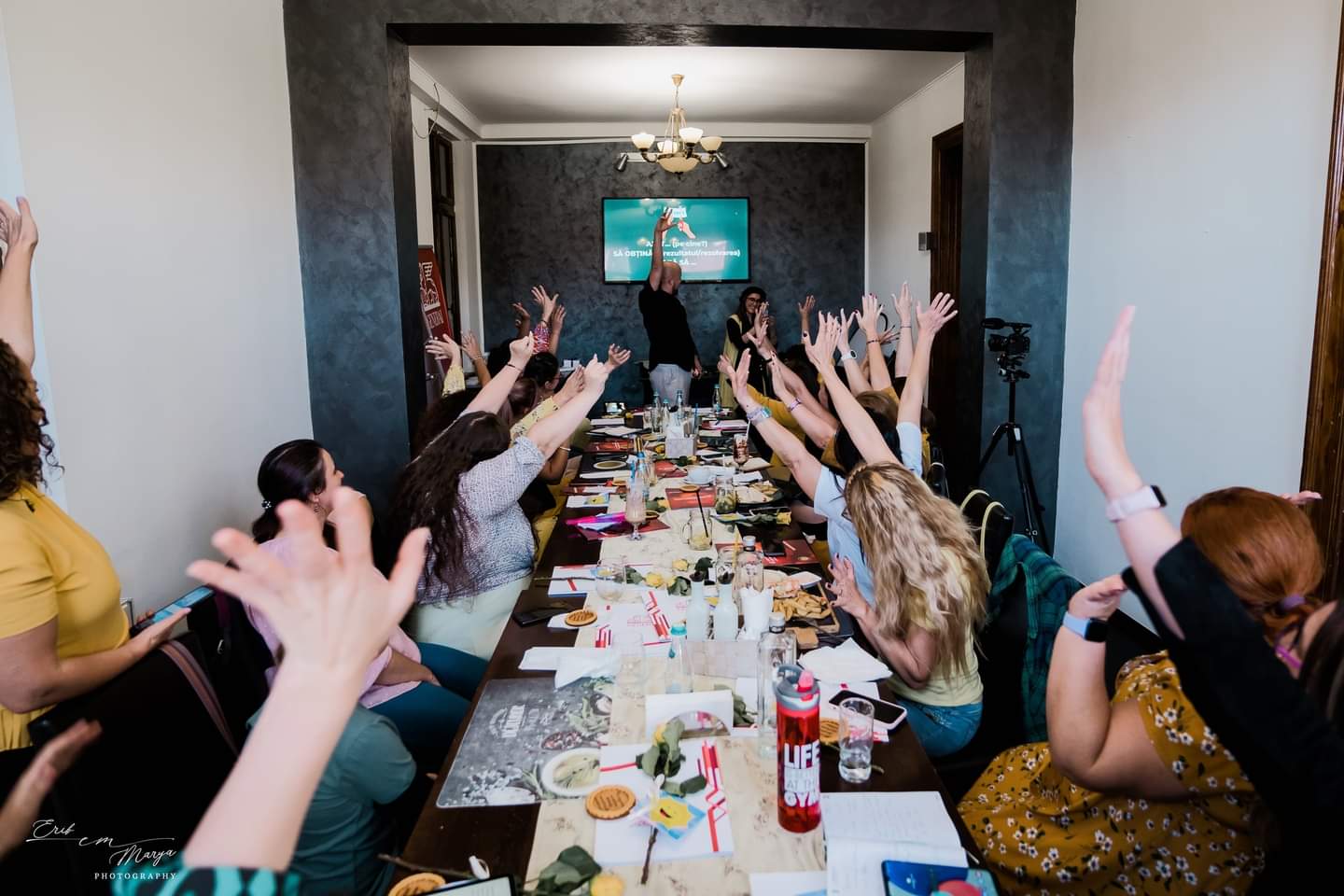 Daniel Bărnuți live workshop participants with hands raised, energy in the room